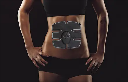 woman using EMS on her ABS on a blck background